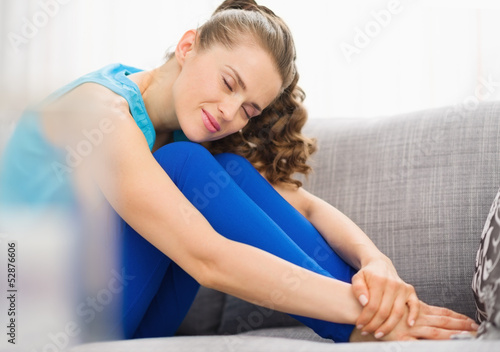 Happy young woman sitting on couch in living room