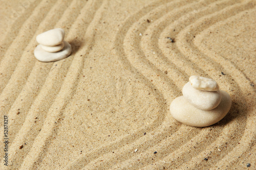 Zen garden with raked sand and round stones close up