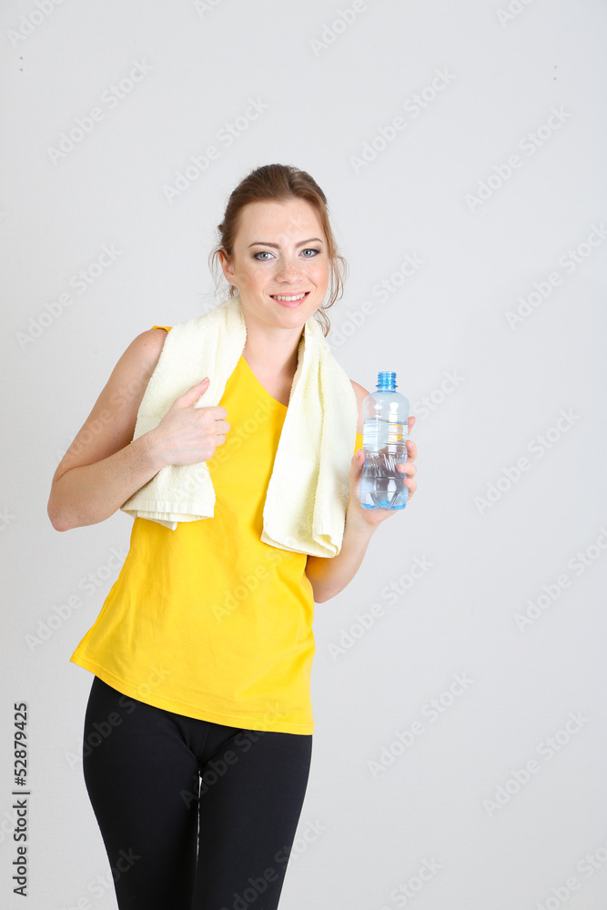 Beautiful young woman with bottle of water and towel Beautiful young woman with bottle of water and towel