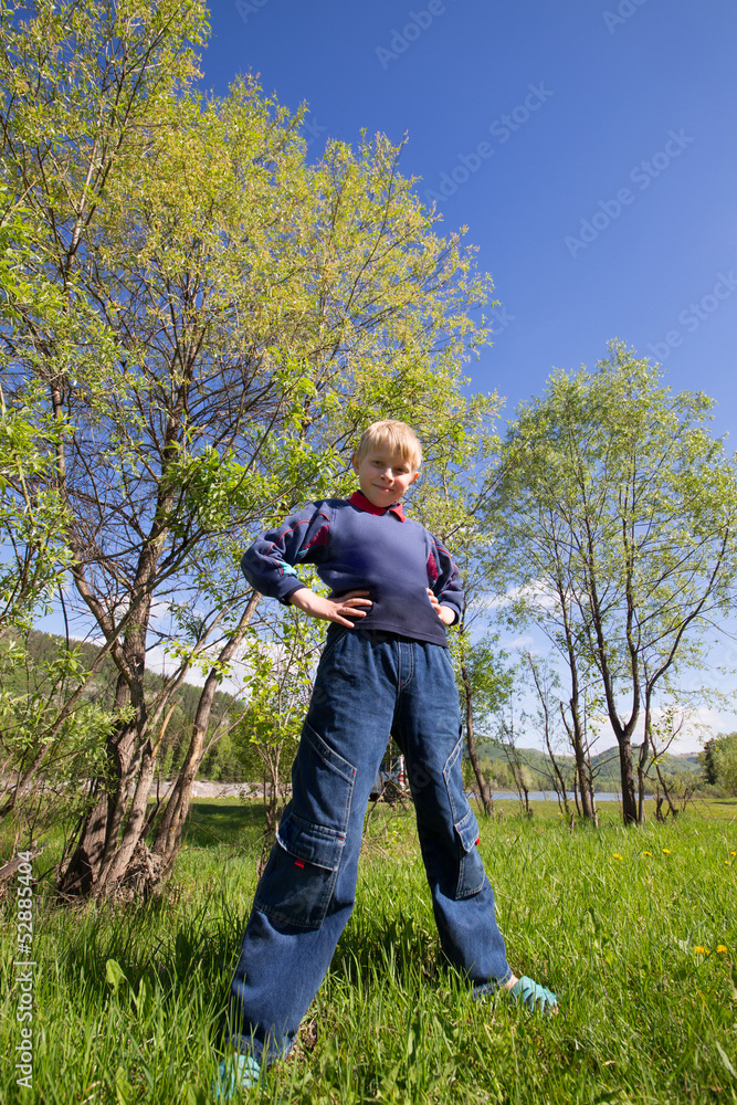 boy stands on the grass boy stands on the grass