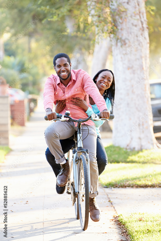 Couple Cycling Along Suburban Street Together