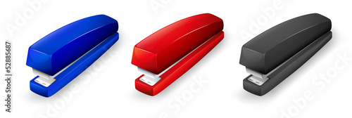 Three different colors of staplers