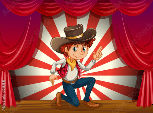A boy kneeling at the center of the stage