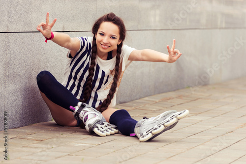 girl going rollerblading sitting putting on inline skates