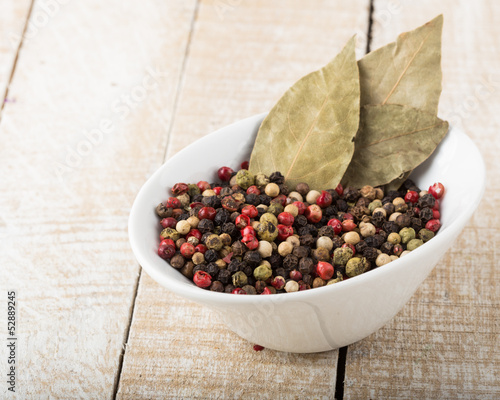 Mixed pepper white bowl on wooden background