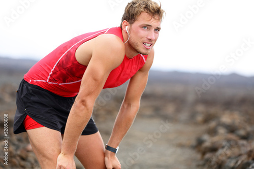 Runner man resting with music after running