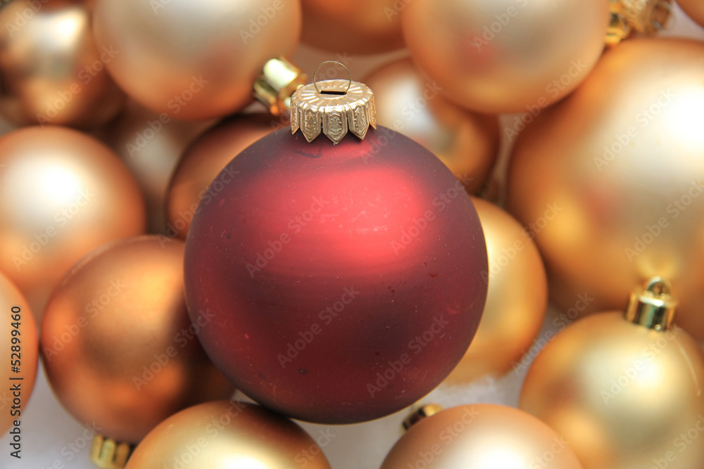 Red ornament on a pile of golden ornaments Red ornament on a pile of golden ornaments