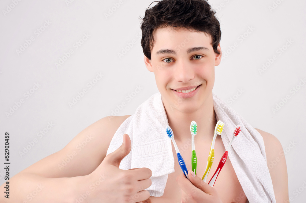 Man with beautiful teeth smiling and holding toothbrushes Man with beautiful teeth smiling and holding toothbrushes