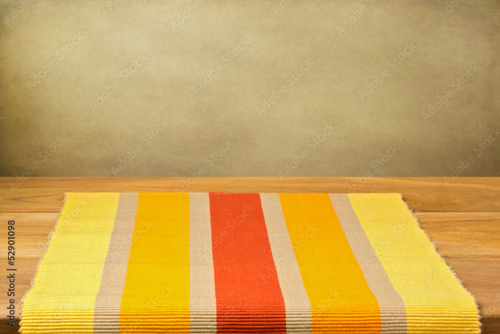 Background with empty wooden table with striped tablecloth