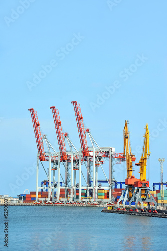 Port cargo crane and container over blue sky background