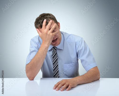 Businessman do a facepalm on white table photo