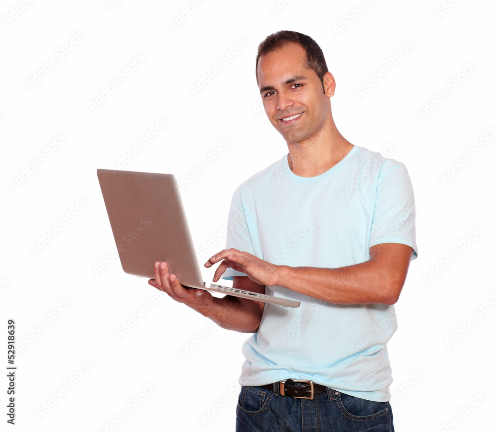 Smiling latin adult man using his laptop computer Smiling latin adult man using his laptop computer