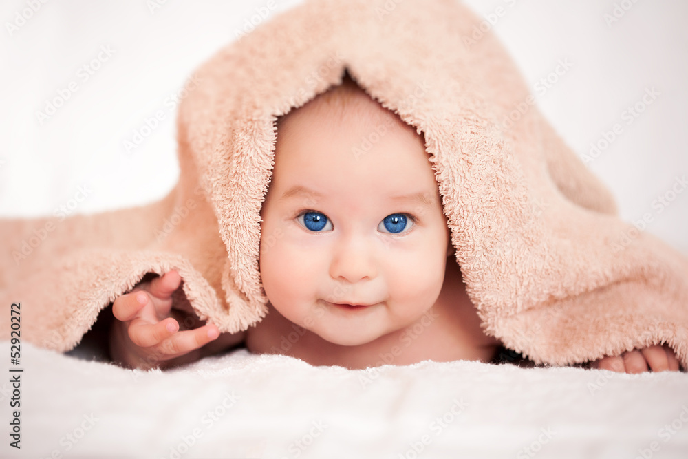 baby is hiding under the beige terry towel baby is hiding under the beige terry towel