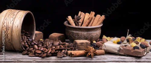 Chocolate bar and spices on wooden table