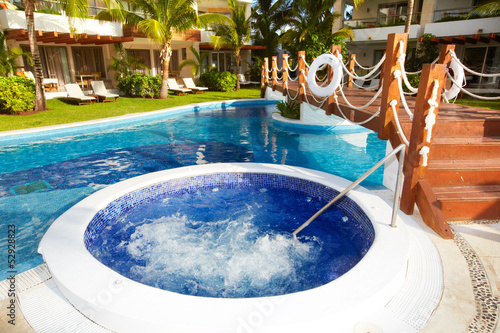 Jacuzzi and a swimming pool at caribbean resort.