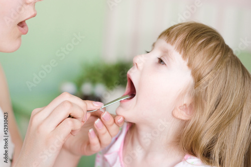 Pediatrician examining little girl's throat