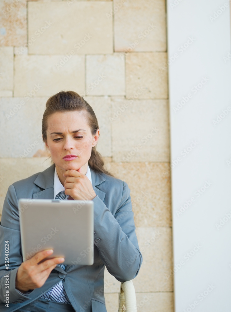 Thoughtful business woman looking in tablet pc Thoughtful business woman looking in tablet pc
