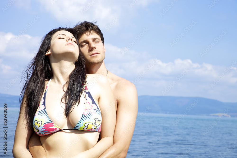 Beautiful woman hugged by handsome man in the water