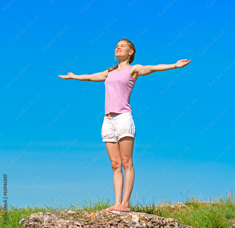 Beautiful athletic girl standing on the stone in the morning Beautiful athletic girl standing on the stone in the morning