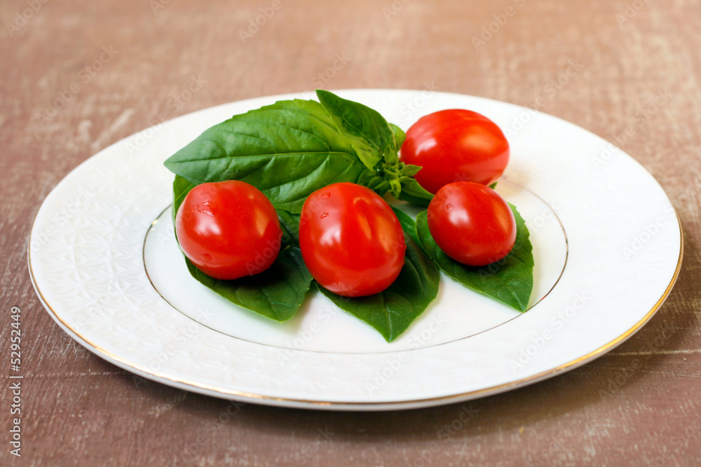 Cherry tomatoes and basil leaves Cherry tomatoes and basil leaves