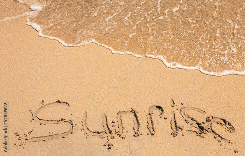 word sunrise written in the sand