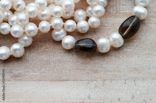 Pearl nacklace with quartz on wood background with copy space