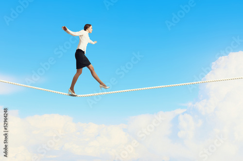 Businesswoman balancing on rope