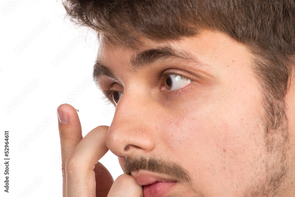 Obraz premium Closeup view of a man's brown eye while inserting a corrective c