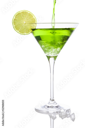 Pouring a green cocktail into a martini glass