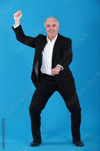 Fotografie Strange businessman pretending to ride a horse