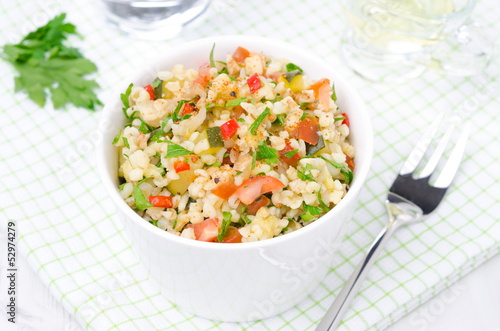 white bowl of salad with bulgur, zucchini, tomatoes and parsley