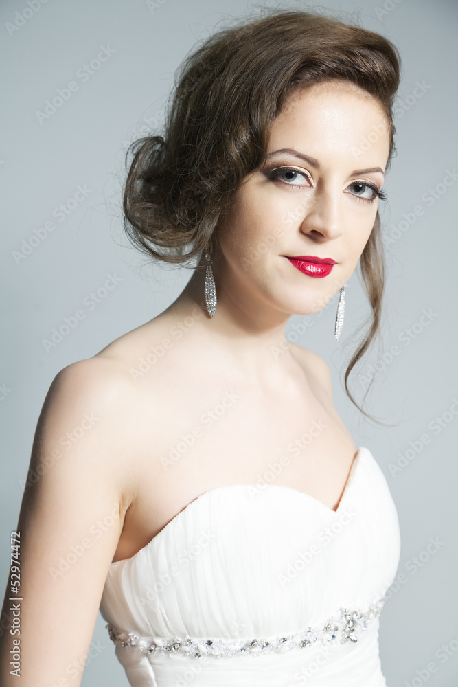 Studio portrait of young bride in white dress