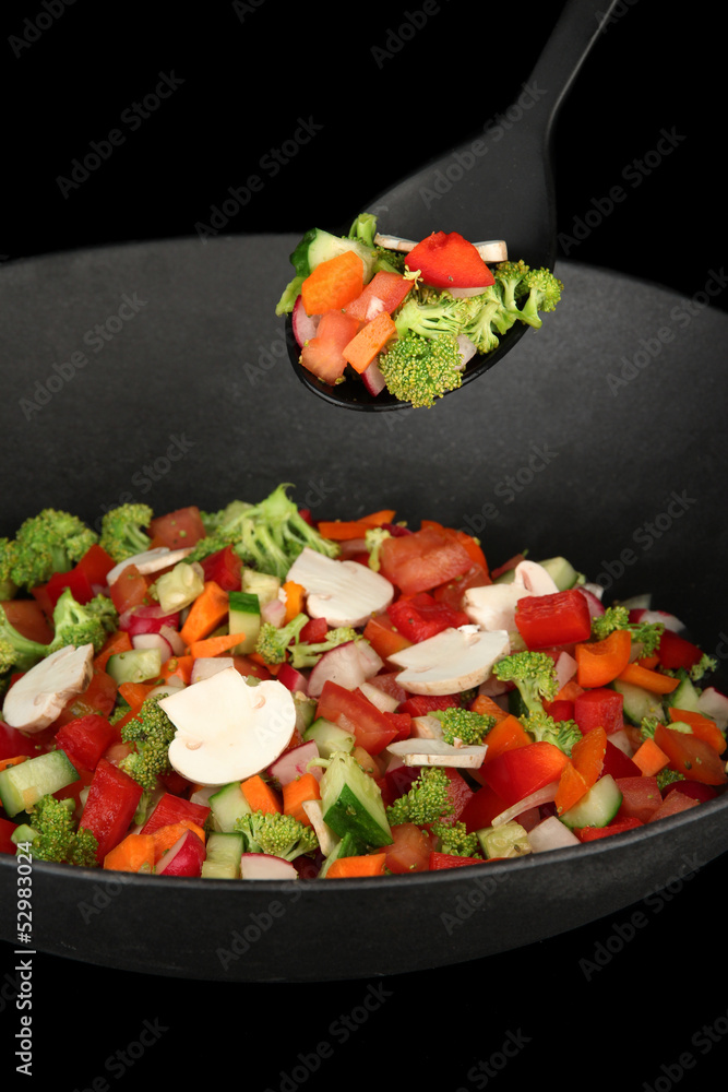 Vegetable ragout in wok, isolated on black