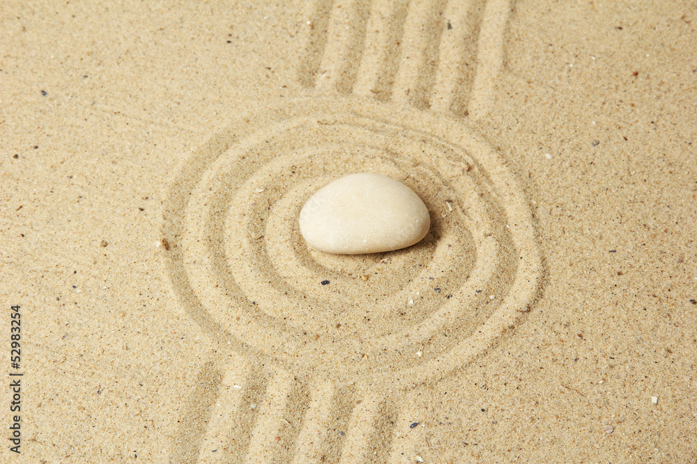 Obraz premium Zen garden with raked sand and round stone close up