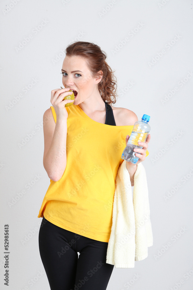 Beautiful young woman with bottle of water and apple Beautiful young woman with bottle of water and apple