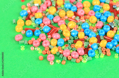 Different colorful beads on green background