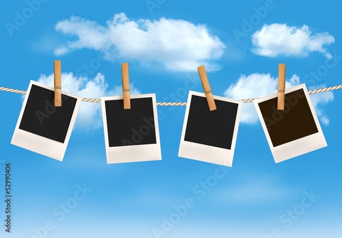 Background with photos hanging on a rope in front of a blue sky