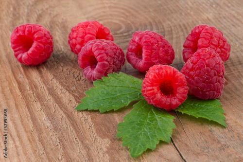 raspberry with leafs on old wooden table