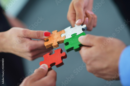 Group of business people assembling jigsaw puzzle photo