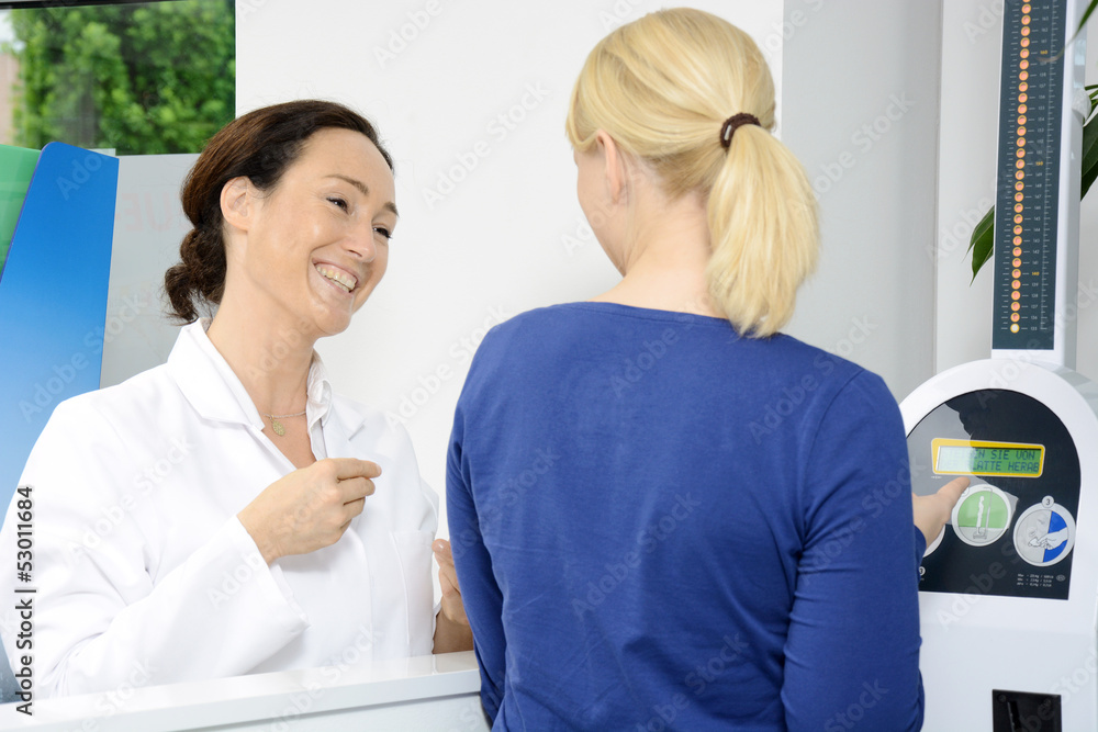 Fototapeta premium Apothekerin berät zu Gewicht und Körpergröße