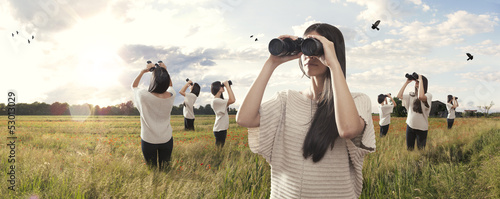 Multiplied girl looking with binoculars