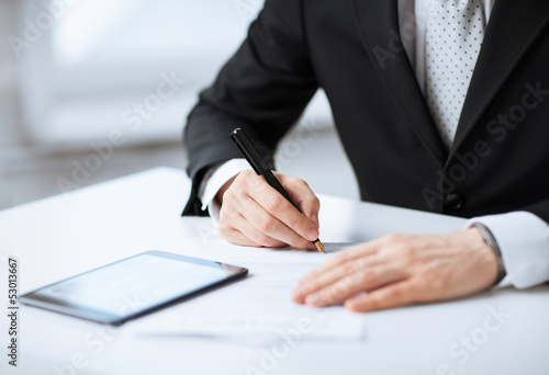 man with tablet pc signing paper