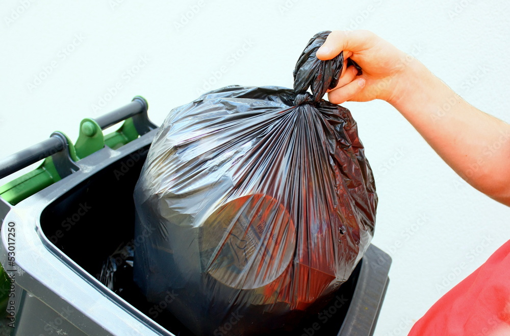 jeter son sac poubelle noir dans un container Stock Photo | Adobe Stock