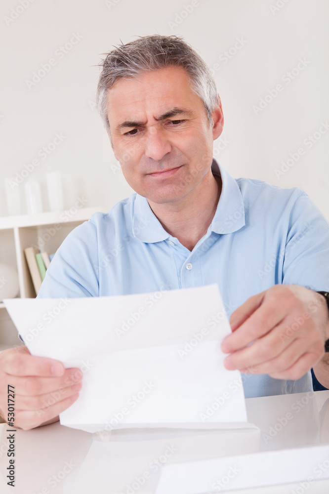 Horrified old man reading a letter Horrified old man reading a letter