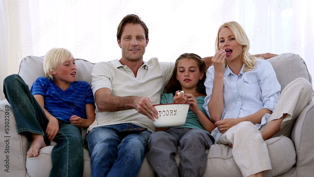 Family watching tv and eating popcorn Family watching tv and eating popcorn