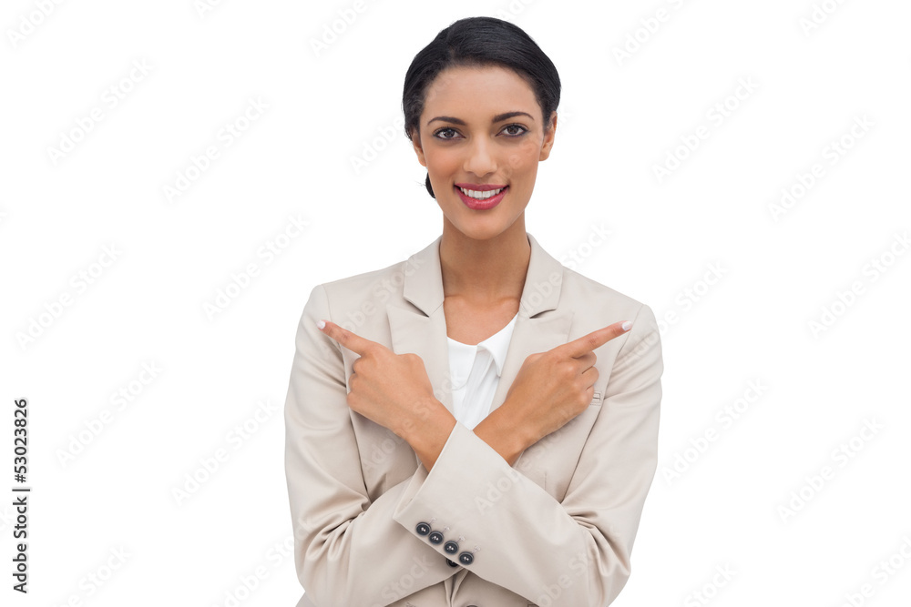 Smiling businesswoman with her arms crossed and fingers pointing