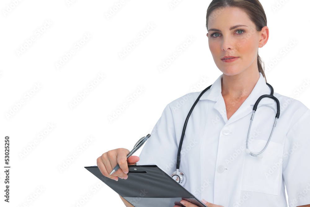 Unsmiling nurse holding clipboard and looking at camera Unsmiling nurse holding clipboard and looking at camera