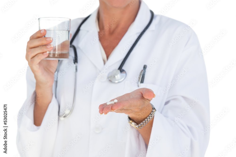 Doctor holding out pills and water glass Doctor holding out pills and water glass