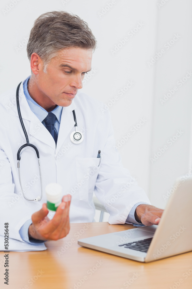 Attractive doctor holding a bottle of pills Attractive doctor holding a bottle of pills
