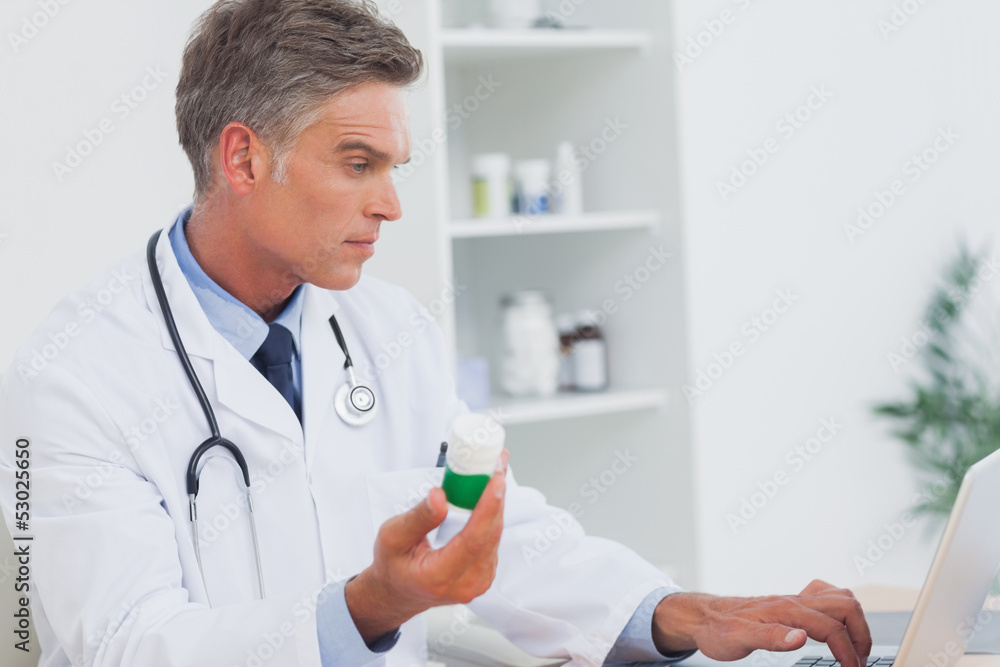 Serious doctor holding pills Serious doctor holding pills